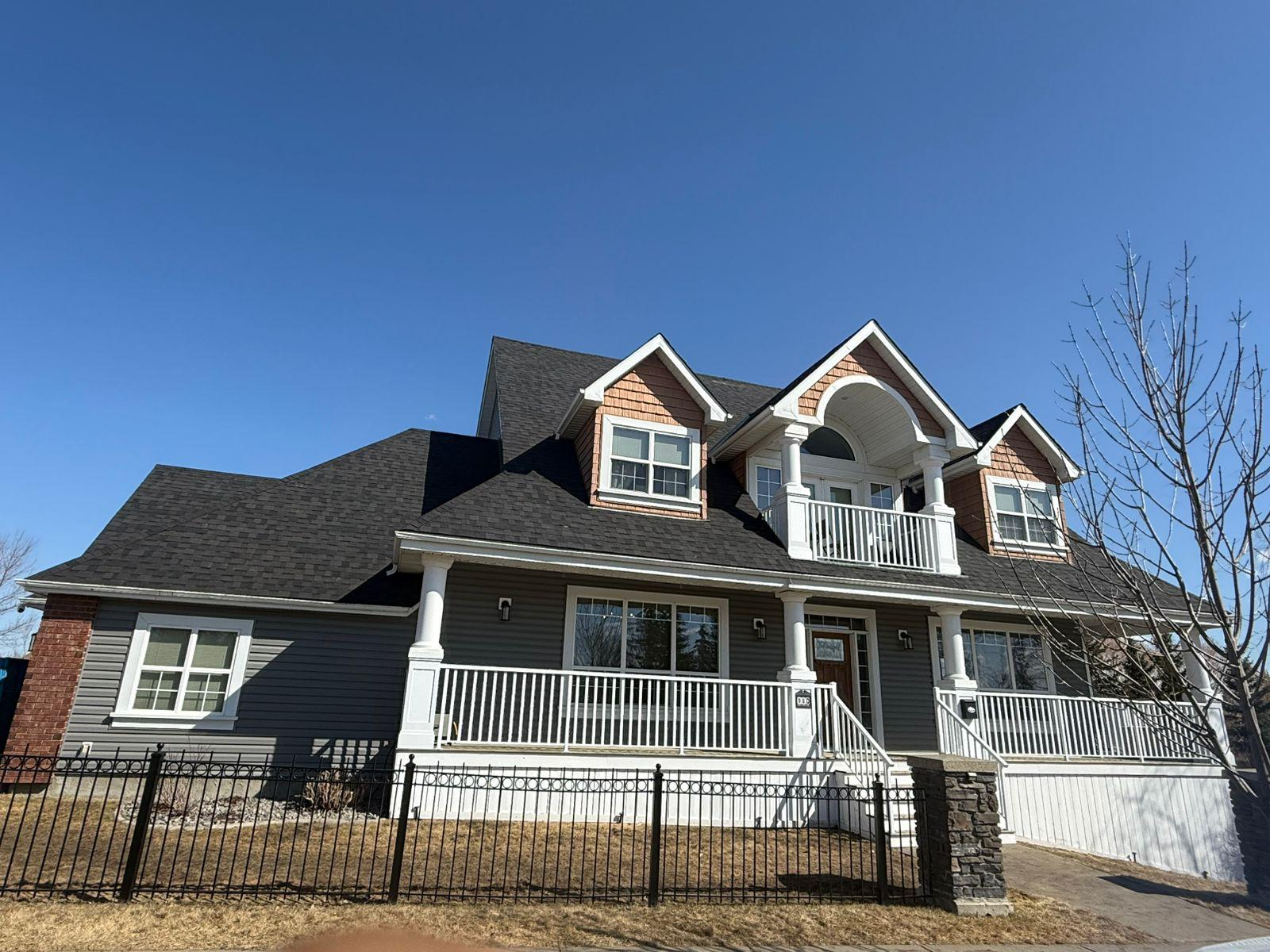 Home with a completed dark asphalt shingle roof by Ariram Roofing